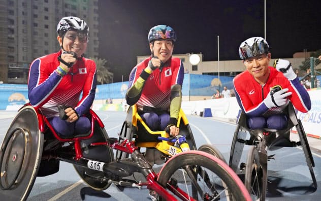 男子1500メートル(車いす)で表彰台を独占し、ガッツポーズする(左から)2位の上与那原寛和、1位の佐藤友祈、3位の伊藤智也=ドバイ(共同) 男子1500メートル(車いす)で表彰台を独占し、ガッツポーズする(左から)2位の上与那原寛和、1位の佐藤友祈、3位の伊藤智也=ドバイ(共同)