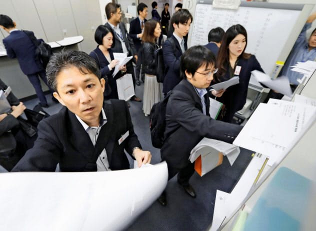 上場企業の4~9月期決算は減益に(東証で資料を投かんする企業の担当者ら、8日) 上場企業の4~9月期決算は減益に(東証で資料を投かんする企業の担当者ら、8日)