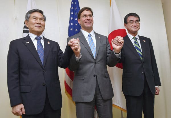 日米韓防衛相会談を前に手をつなぐ(左から)韓国の鄭景斗国防相、エスパー米国防長官、河野防衛相(17日午後、バンコク)=代表撮影