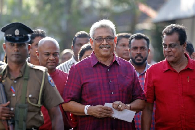 大統領選に勝利したラジャパクサ氏(中)は18日に就任する=AP 大統領選に勝利したラジャパクサ氏(中)は18日に就任する=AP