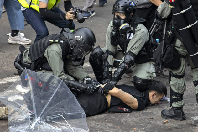 18日、重装備の警察官がデモ参加者を拘束した=AP 18日、重装備の警察官がデモ参加者を拘束した=AP