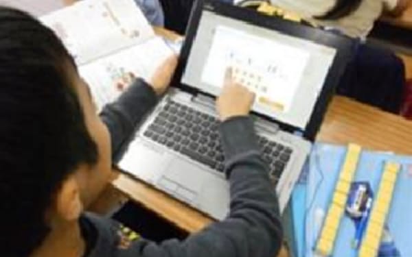 小学校の授業でコンピューターを使う児童（荒川区提供）