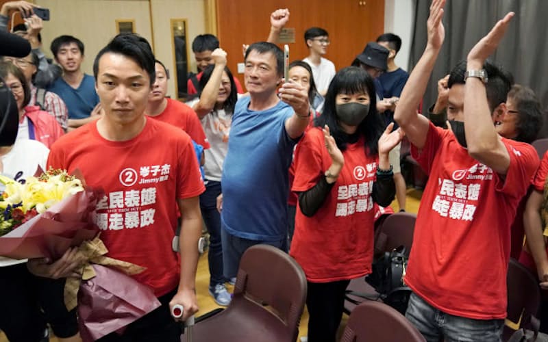 当選を喜ぶ民主派団体の候補者(左)(25日、香港)=共同 当選を喜ぶ民主派団体の候補者(左)(25日、香港)=共同