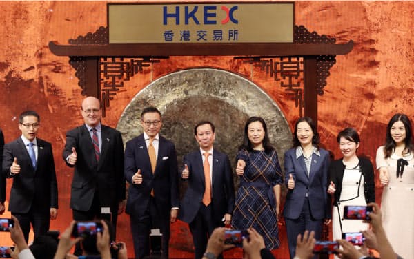 香港取引所への上場を前に記念写真に納まるアリババ集団の張勇(ダニエル・チャン)会長兼CEO(中)(26日午前、香港)=石井理恵撮影