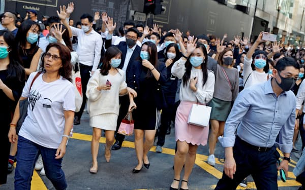 香港の金融街、セントラルでは昼休みに銀行、証券会社などで働く高収入のエリートらがマスク姿で「ランチタイムデモ」に参加している（11月25日）=ロイター