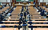 大学入試センター試験で、受験生にリスニング用の機器を配布する担当者（1月19日、東京都文京区の東京大学）