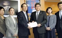 公明党の斉藤幹事長（中央左）から提言書を受け取る萩生田文科相（5日、文科省）=共同