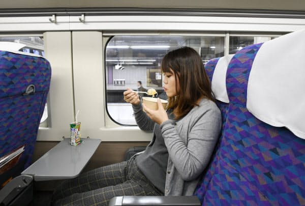 新幹線の車中で食事をとる冨沢友里さん(JR上野駅)