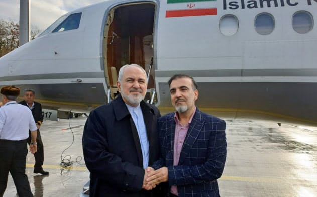 釈放された科学者(右)と握手するイランのザリフ外相(7日、チューリヒ、イラン外相のツイッターから)=AP 釈放された科学者(右)と握手するイランのザリフ外相(7日、チューリヒ、イラン外相のツイッターから)=AP
