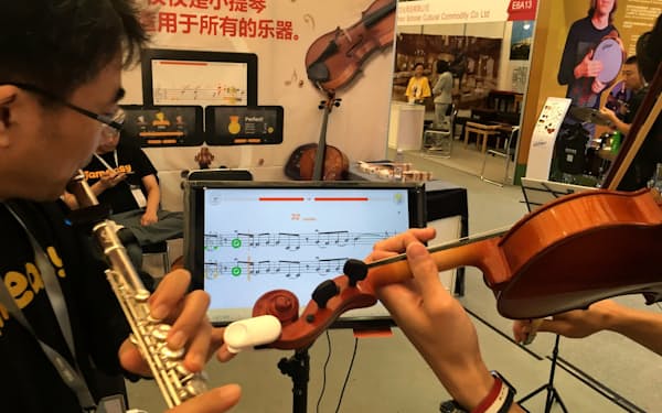 バイオリンに付けた小型センサー端末が演奏の音を読み取って、音階やリズムの間違いを指摘する（ジェムイージーのサービス）
