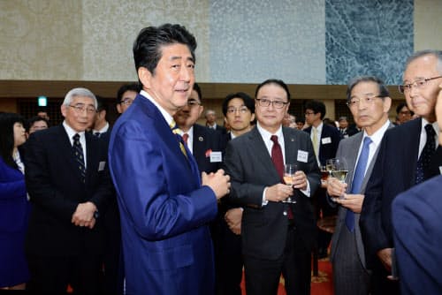 年末エコノミスト懇親会で歓談する安倍首相 ら(11日、東京都港区)