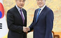中国はTHAAD問題を蒸し返した。5日、ソウルの大統領府で握手する韓国の文在寅大統領（右）と中国の王毅外相（韓国大統領府提供・共同）
