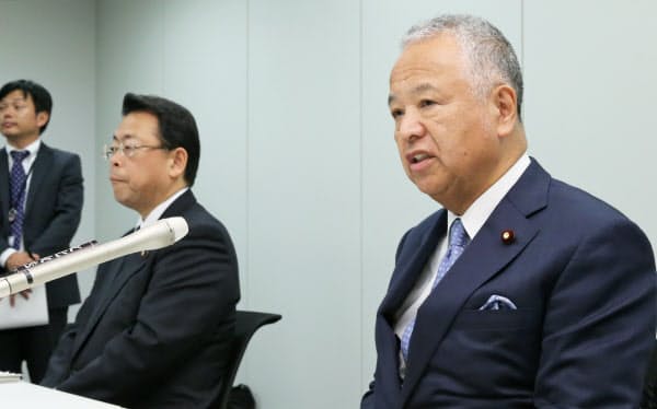 2020年度の与党税制改正大綱が正式決定し、記者会見する自民党の甘利税調会長(右)と公明党の西田税調会長(12日、国会内)