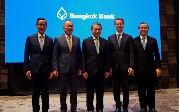 インドネシアのプルマタ銀の買収を発表するタイのバンコク銀のピティ会長(中)ら（12日、バンコク）