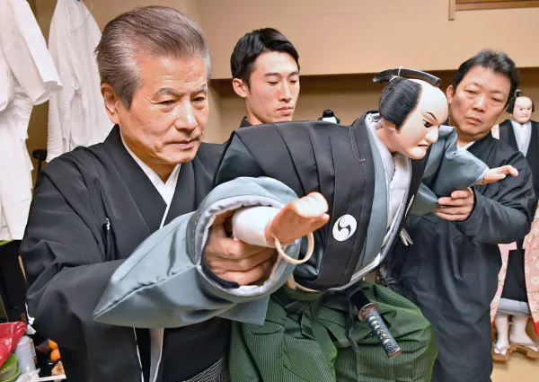 楽屋で弟子を指導する人形遣いの二代吉田玉男(左)(2019年11月、大阪市中央区)
