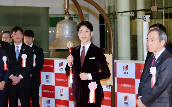 大納会で打鐘する狂言師の野村萬斎さん(中)(30日、東証)