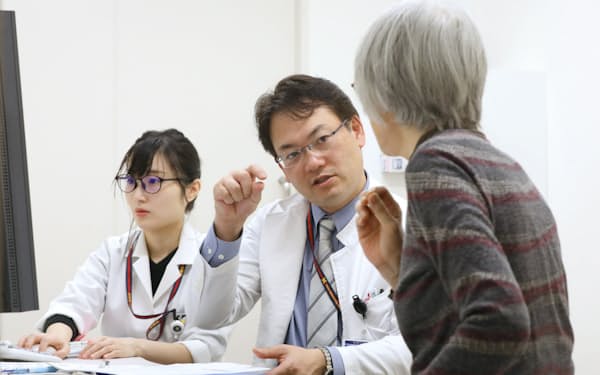 がん遺伝子外来で医師に問診を受けるがん患者(右)（東京都新宿区の慶応義塾大学病院）