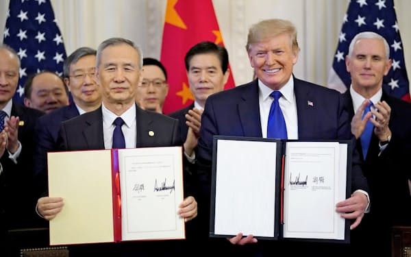 劉氏(左)と第1段階合意に署名し笑顔をみせるトランプ氏（15日、ホワイトハウス）=ロイター