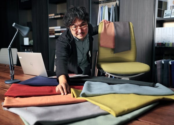 生地を並べ、オフィスチェアの色を検討する大木さん=小幡真帆撮影