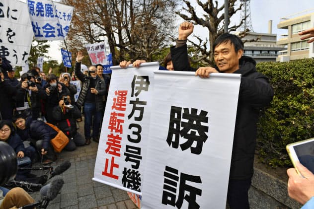 広島高裁が四国電力伊方原発3号機の運転を差し止める仮処分を決定し、垂れ幕を掲げ喜ぶ住民側関係者(17日午後) 広島高裁が四国電力伊方原発3号機の運転を差し止める仮処分を決定し、垂れ幕を掲げ喜ぶ住民側関係者(17日午後)