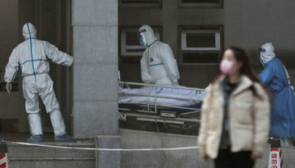 新型肺炎の患者を搬送する医療スタッフ(20日、武漢市)=ロイター