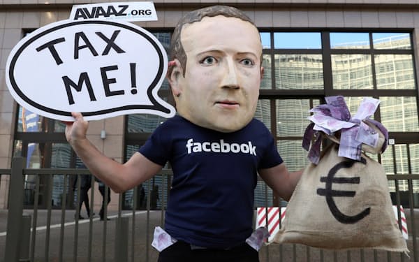 ブリュッセルのEU本部前でフェイスブックのザッカーバーグCEOにふんしてデジタル課税を訴える人物=ロイター
