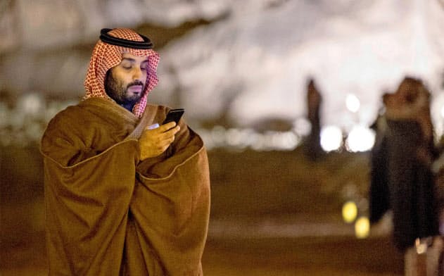 12日、リヤドで携帯電話を使うサウジのムハンマド皇太子=ロイター 12日、リヤドで携帯電話を使うサウジのムハンマド皇太子=ロイター