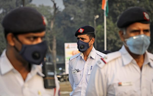 大気汚染から身を守るため、マスクをして交通整理にあたる警官ら（ニューデリー）=ロイター