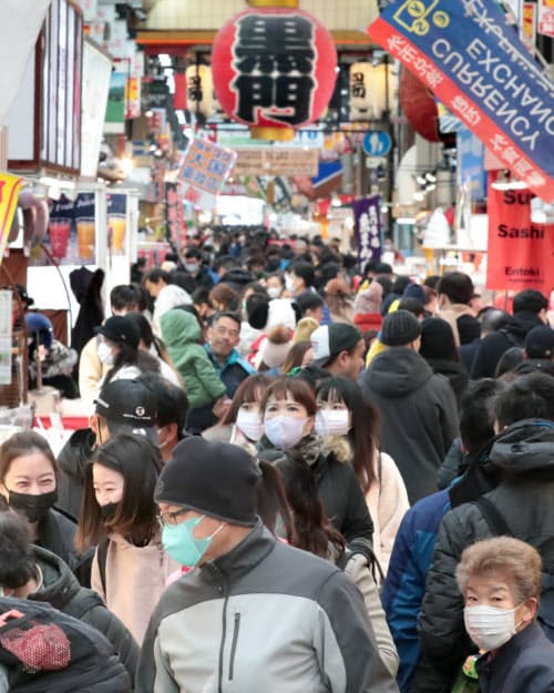 マスクをして買い物する観光客ら(27日、大阪市中央区の黒門市場)