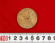 櫟本チトセ遺跡の井戸から出土した小型銅鏡(28日、奈良県天理市)=共同 櫟本チトセ遺跡の井戸から出土した小型銅鏡(28日、奈良県天理市)=共同