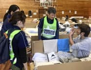 台風19号で被災し避難した武田隆志さん(右端)を支援する鳥取県から派遣されたチームのメンバーら(2019年10月、長野市)=(鳥取県提供・共同  台風19号で被災し避難した武田隆志さん(右端)を支援する鳥取県から派遣されたチームのメンバーら(2019年10月、長野市)=(鳥取県提供・共同