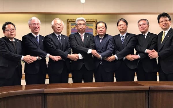 共同経営の方向で合意した熊本のバス5社社長と熊本市の大西市長(右)ら（27日、熊本市役所）
