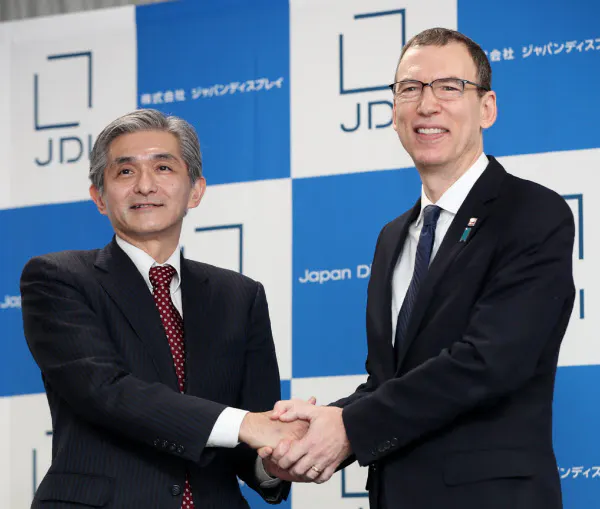 握手するジャパンディスプレイの菊岡稔社長(左)といちごアセットマネジメントのスコット・キャロン社長(31日、東京都港区)