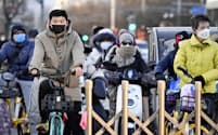 春節の大型連休が明け、マスク姿で行き交う北京市民ら（3日）=共同
