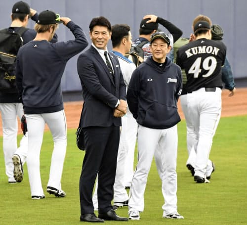 日本ハムキャンプを訪れ、栗山監督(右)と談笑する日本代表の稲葉監督(3日、名護)=共同