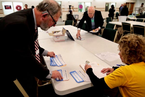 民主党のアイオワ州党員集会での票を集計する関係者ら(3日)=ロイター