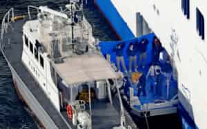 横浜・大黒ふ頭沖に停泊するクルーズ船「ダイヤモンド・プリンセス」から海上保安庁の巡視艇に乗り込む関係者(5日午前)=共同 横浜・大黒ふ頭沖に停泊するクルーズ船「ダイヤモンド・プリンセス」から海上保安庁の巡視艇に乗り込む関係者(5日午前)=共同