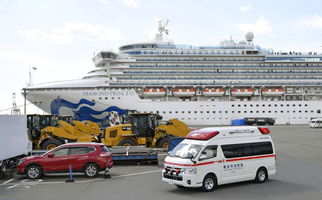 クルーズ船「ダイヤモンド・プリンセス」が停泊する横浜港から出る救急車(18日)=共同 クルーズ船「ダイヤモンド・プリンセス」が停泊する横浜港から出る救急車(18日)=共同