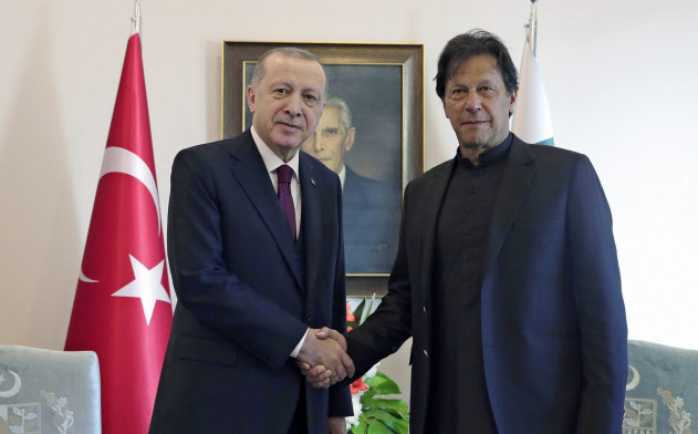 14日、握手を交わすパキスタンのカーン首相(右)とトルコのエルドアン大統領(イスラマバード)=AP 14日、握手を交わすパキスタンのカーン首相(右)とトルコのエルドアン大統領(イスラマバード)=AP