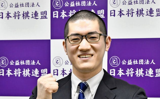 棋士編入試験5番勝負の第4局で勝利し、笑顔で記念撮影に応じる折田翔吾さん(25日、東京都渋谷区の将棋会館)=共同 棋士編入試験5番勝負の第4局で勝利し、笑顔で記念撮影に応じる折田翔吾さん(25日、東京都渋谷区の将棋会館)=共同