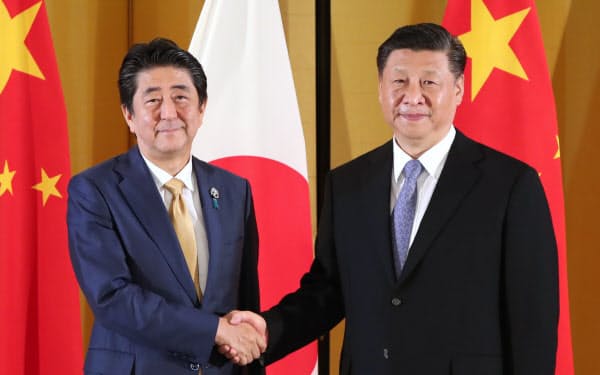 中国の習近平国家主席(右)と握手する安倍首相(2019年6月27日、大阪市)
