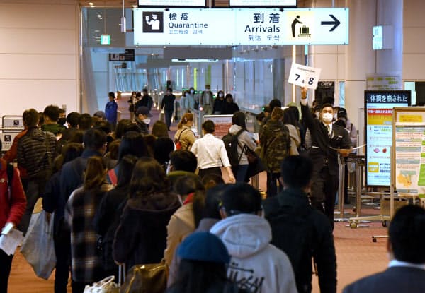 中国からの便で羽田空港に到着した乗客ら(8日)