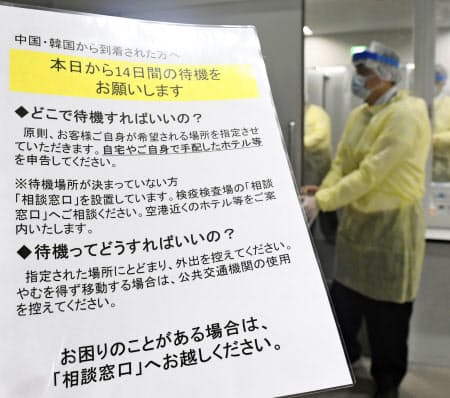 中国と韓国から成田空港に到着した乗客向けに書かれた14日間の待機を求める注意書き=9日午前