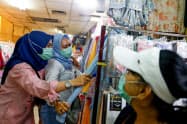 9日、ジャカルタでマスクをつけて市場を訪れる買い物客=ロイター 9日、ジャカルタでマスクをつけて市場を訪れる買い物客=ロイター