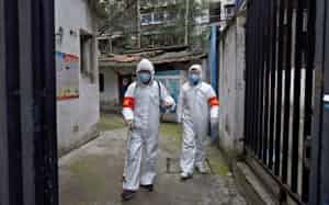防護服に身を包んで武漢の街を消毒する作業担当者(6日)=ロイター 防護服に身を包んで武漢の街を消毒する作業担当者(6日)=ロイター