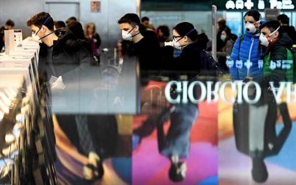 航空会社のカウンターに並ぶ利用客(9日、イタリア・ミラノのマルペンサ空港)=ロイター