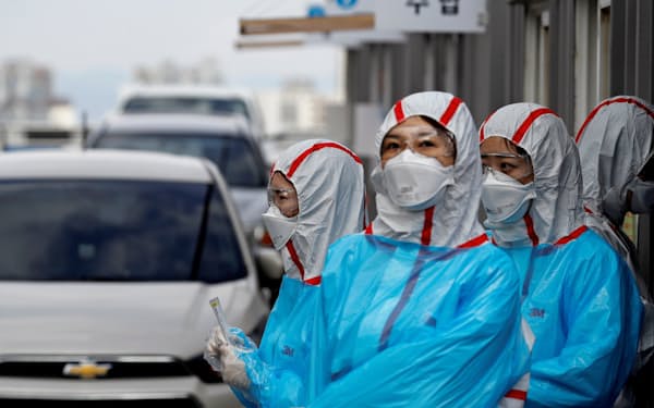 韓国大邱市で通行車両の乗員に新型コロナウイルスの検査をする医療スタッフ=ロイター