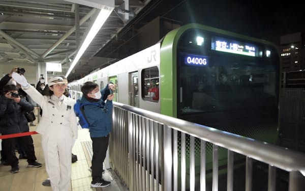 開業したJR「高輪ゲートウェイ駅」を出発する山手線の始発列車（14日午前、東京都港区）