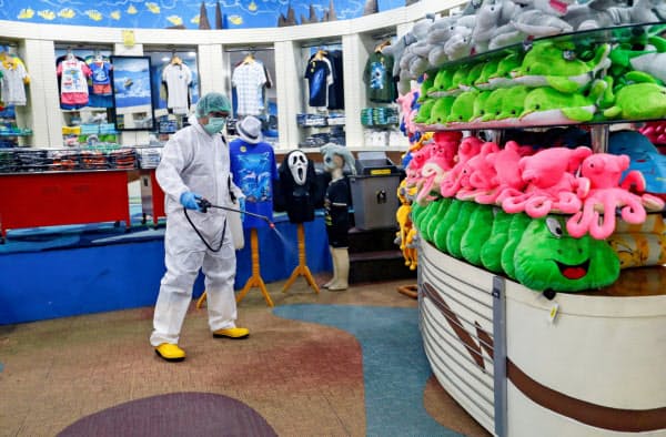 14日、休業した州政府系のレジャー施設を消毒する作業員=ロイター