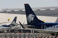 アエロメヒコは日本への運航も減少させる(メキシコシティ国際空港で待機するアエロメヒコの航空機)=ロイター アエロメヒコは日本への運航も減少させる(メキシコシティ国際空港で待機するアエロメヒコの航空機)=ロイター